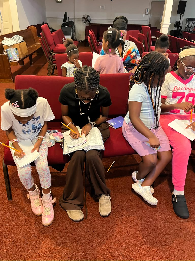 Children working through their Bible study workbooks