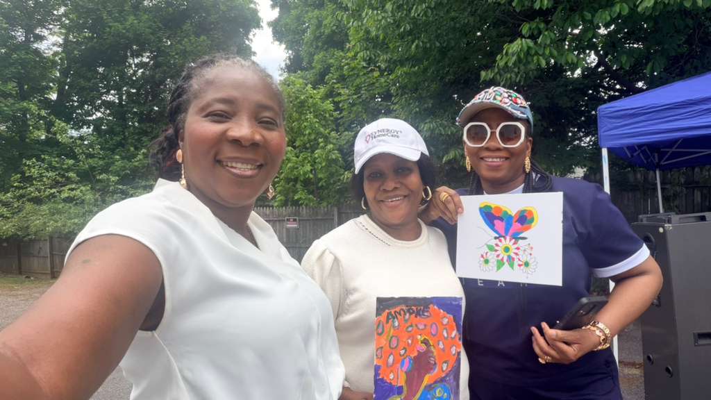 Women of the church holding the paintings they made together